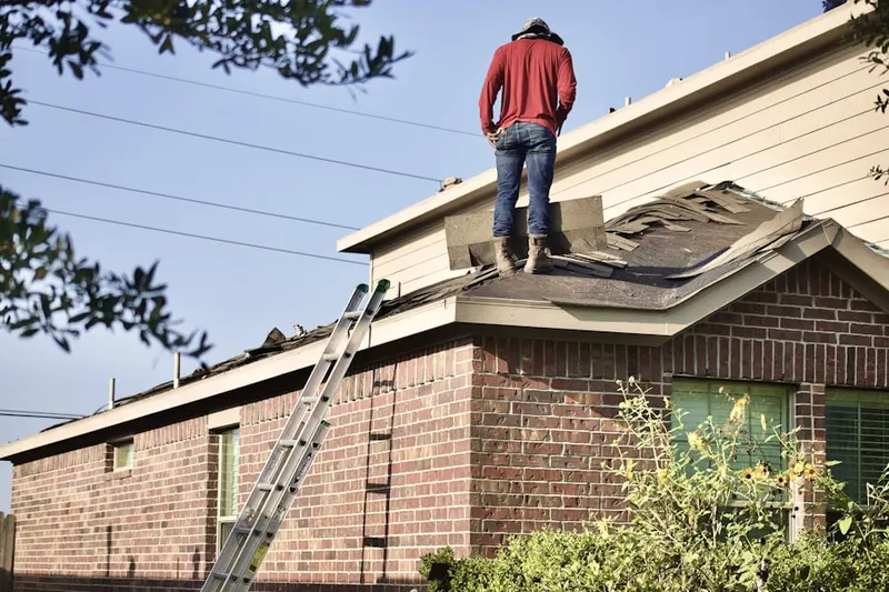 Professional roofer working on a residential roof in Navasota